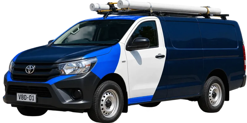 A licensed Marrickville plumbing van loaded with pipe on the roof rack